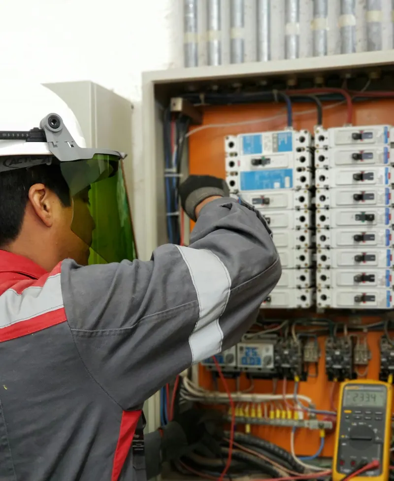 Électricien qui intervient sur un tableau électrique ouvert